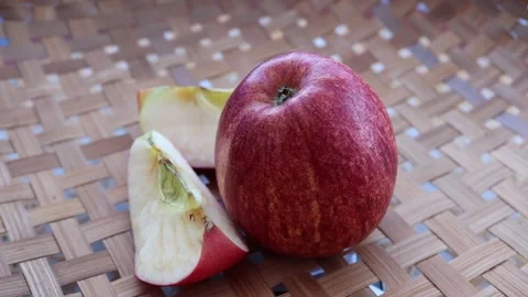 Red apple and slices rotating on wicker tray Stock Footage 139856756