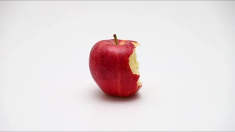 Red apple bitten and eaten over time, disappearing into nothingness on whit.. Stock Footage 337164772