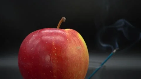 Red apple on black background and smoldering stick Stock Footage 141629384