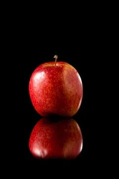 Red apple on a black reflective background Stock Photos