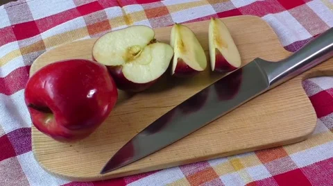 Red apple on the board with knife on the table Stock Footage 58944989