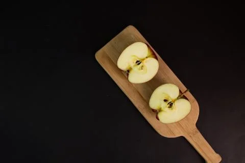 Red apple cut in half on table on elegant black background. healthy food 库存照片