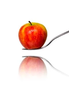 An red apple on a fork with reflection, isolated on white Stock Photos