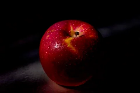Red apple fruit in low light. Stock Photos