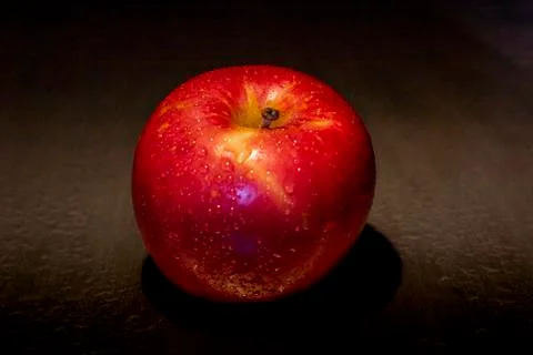 Red apple fruit in low light. Stock Photos