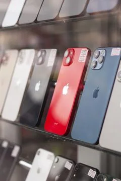 Red Apple mobile phone, iPhone smartphone on shelf Stock Photos