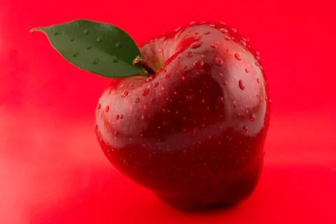Red apple on a red background Stock Photos
