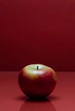 A red apple on a red background Stock Photos