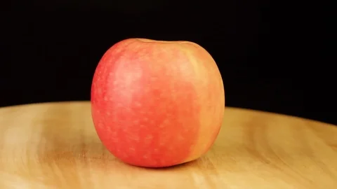 Red Apple rotates 360 degrees on a wooden stand Stock Footage 119176364