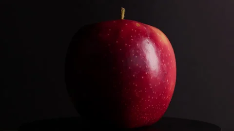 A red apple rotates around its axis on a black background Stock Footage 330687231