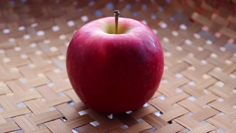 Red apple is rotating on wicker tray Stock Footage 139855594