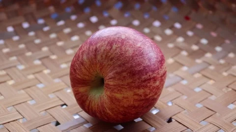Red apple is rotating on wicker tray Stock Footage 139855833