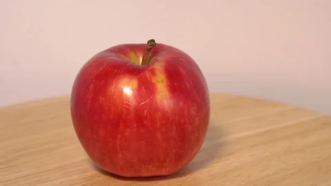 Red apple rotating on wooden table Stock Footage 76542552