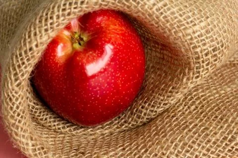 Red apple sackcloth on background Stock Photos