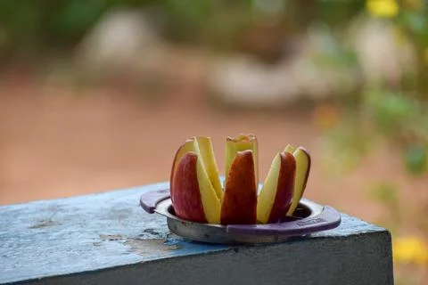 A red apple is sliced on a plate Stock Photos
