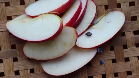 Red apple slices rotating on wicker tray Stock Footage 139857813