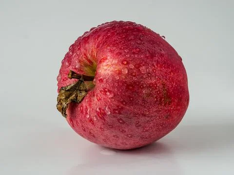 Red apple with a small leaf, water drops close-up Stock Photos