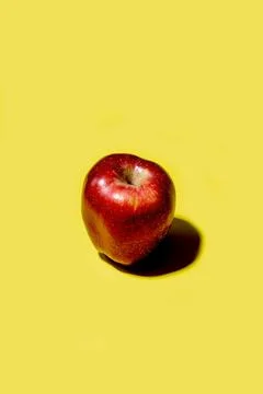Red apple on a solid yellow background 스톡 사진