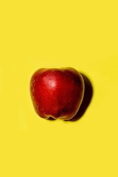 Red apple on a solid yellow background 스톡 사진