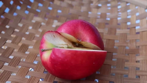Red apple two halves slice rotating on wicker tray Stock Footage 139856309