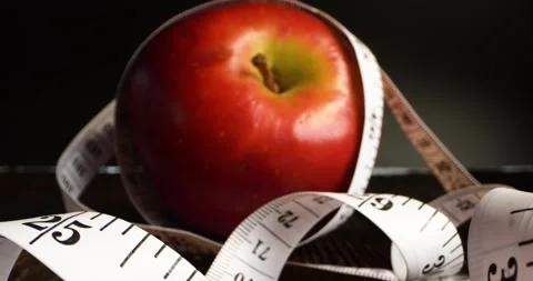 Red apple wrapped with measuring tape. Diet, healthy eating, weight loss concept Stock Footage 155529320