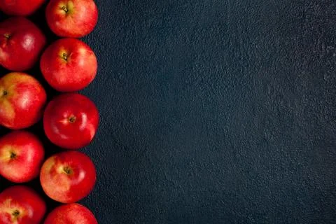 Red Apples Aligned Vertically on Dark Blue Textured Background 스톡 사진