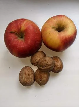 Red apples and nuts on the table. Stock Photos