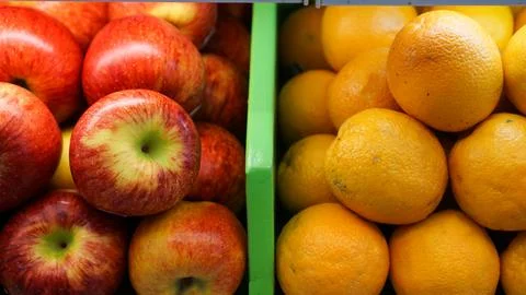 Red apples and oranges side by side in the shop and market. Contrast color .. Foto stock
