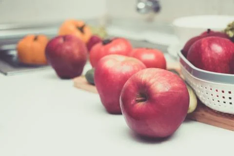 Red apples are placed on the table in the kitchen. Stock Photos