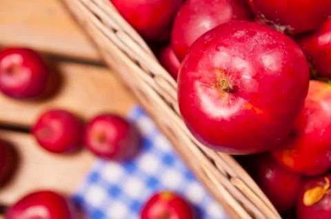 Red apples in a basket on table Stock Photos