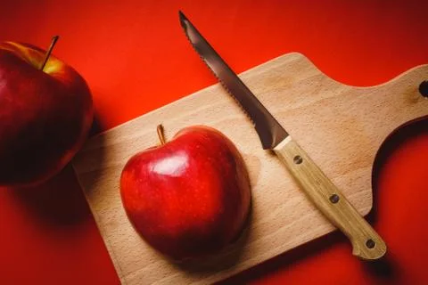 Red apples chopped up on the board on a table Foto stock