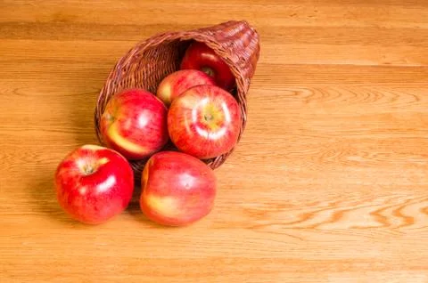 Red apples on table in cornucopia Stock Photos