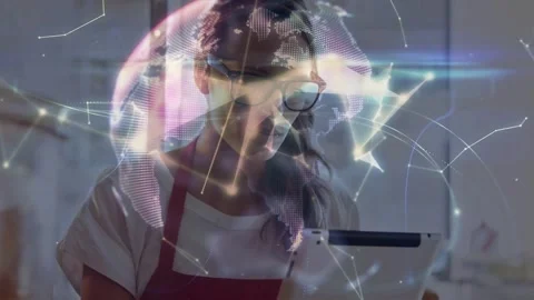 Red apron shop worker tapping tablet and causing animated nodes forming globe Stock Footage 333936429