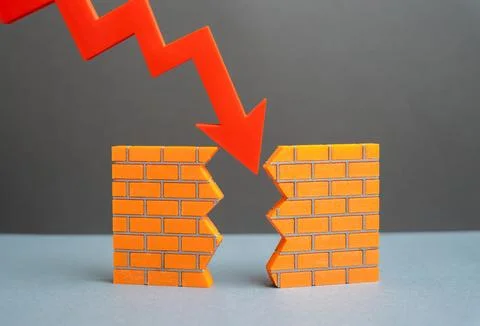 A red arrow breaks down a wall. The crisis destroys the foundations of the ec Stock Photos