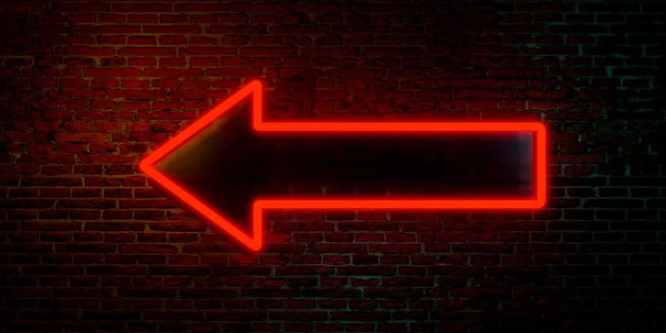 Red arrow, left direction. Red arrow, left direction. Brick wall with neon... Stock Photos
