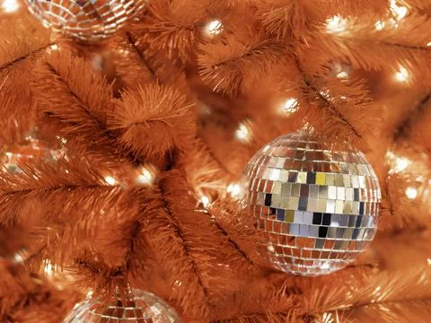 Red artificial Christmas tree with mirror disco balls. Bright fir tree decora Stock Photos
