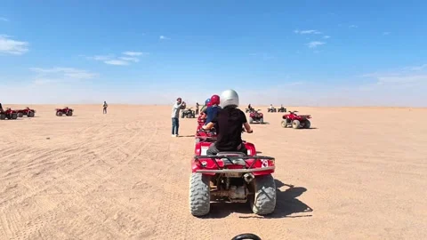 Red ATVs are parked next to participants preparing for their adventure. Video stock 336974698