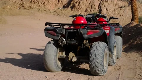 Red ATVs stands in the parking lot in the desert against the backdrop of mountai 스톡 동영상 237446792