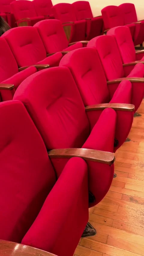 Red auditorium chairs aligned in rows indoors, empty theater seating, event and Stock Footage 333915791