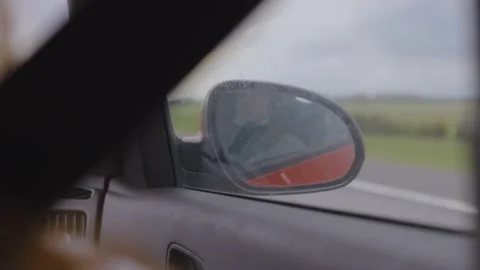Red automobile, the road is reflected in the long-distance mirror of the car Stock Footage 154400582
