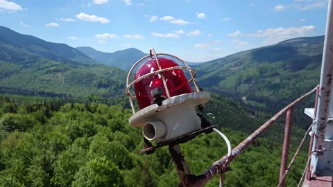 Red aviation warning light on 75m tower with mountain panorama Stock Footage 338115359