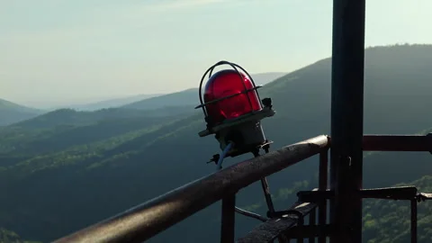 Red aviation warning light on 75m tower with mountain panorama Stock Footage 338115627