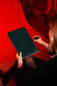 Red backdrop frames a dark green notebook Stock Photos