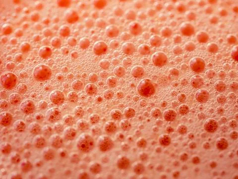 Red background of air bubbles on the surface of fruit juice. texture macro .. Stock Photos