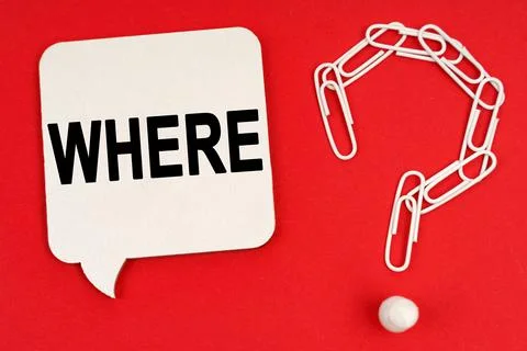 On a red background are a question mark made of paper clips and a sign with t Stock Photos