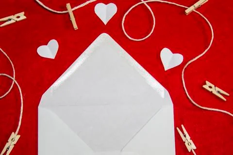 A red background from felt. A composition from heart, thread and clothespins. Stock Photos