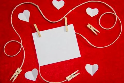 A red background from felt. A composition from heart, thread and clothespins. Foto stock