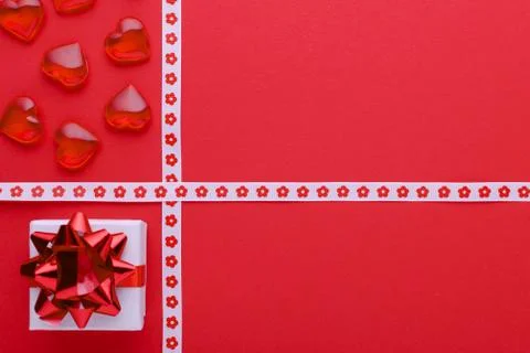 Red background with gift box and hearts, copy space Stock Photos