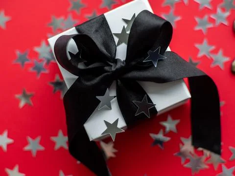 Red background with gift box and silver stars Stock Photos