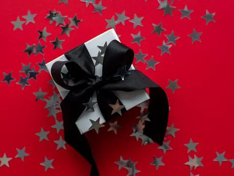 Red background with gift box and silver stars Stock Photos